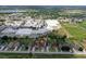 An aerial shot of identical houses shows consistent landscaping and manicured lawns lining the street at 1197 E Grove Ave, Lake Wales, FL 33853