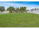 Expansive backyard featuring a well-maintained lawn, mature trees, and a white perimeter fence at 1197 E Grove Ave, Lake Wales, FL 33853
