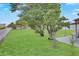 Spacious backyard with a lush lawn, trees, a patio area, and a white fence at 1197 E Grove Ave, Lake Wales, FL 33853