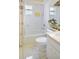 Bathroom with white tiled shower and walls, contrasting with neutral-colored tile floors at 1197 E Grove Ave, Lake Wales, FL 33853
