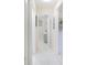 Hallway with tiled floor leading to a bedroom; neutral color scheme, and decorative touches at 1197 E Grove Ave, Lake Wales, FL 33853