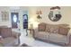 Inviting living room with couch, chair, tile flooring and a view to the front door at 1197 E Grove Ave, Lake Wales, FL 33853