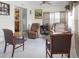Sunroom featuring tiled floor, a pair of upholstered chairs, and a desk and chairs in background at 1197 E Grove Ave, Lake Wales, FL 33853