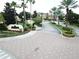 Elegant community entrance with lush landscaping, palm trees, and well-paved roads at 12021 Villanova Dr # 111, Orlando, FL 32837