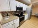 Bright kitchen featuring white cabinets, stainless steel appliances, and granite countertops at 12021 Villanova Dr # 111, Orlando, FL 32837