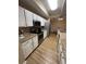 Modern kitchen features white cabinets, granite countertops, stainless steel appliances, and wood-look flooring at 12021 Villanova Dr # 111, Orlando, FL 32837