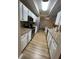 Modern kitchen features white cabinets, granite countertops, stainless steel appliances, and wood-look flooring at 12021 Villanova Dr # 111, Orlando, FL 32837