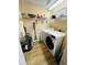 Small laundry room with washer, dryer, shelving and wood look floors at 12021 Villanova Dr # 111, Orlando, FL 32837