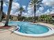 A gorgeous community pool with crystal clear water is surrounded by brick-paved area and palm trees at 12021 Villanova Dr # 111, Orlando, FL 32837