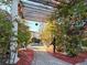 Charming pergola draped in flowering vines, leading to a secluded spa area, perfect for relaxation and tranquility at 12021 Villanova Dr # 111, Orlando, FL 32837