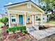 Charming home featuring a cozy front porch, a blue door, and freshly landscaped yard with plants and flowers at 13 E 8Th St, Frostproof, FL 33843