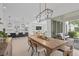 Open-concept dining area with wood table, leading to modern kitchen and outdoor patio at 14081 Gullstrand Ave, Orlando, FL 32827