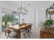 Charming dining area with rustic wood table, modern chandelier, and sliding glass doors to patio at 14081 Gullstrand Ave, Orlando, FL 32827