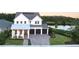 Stunning two-story home with three-car garage and inviting front porch overlooking a tranquil lake at 14081 Gullstrand Ave, Orlando, FL 32827