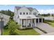 Charming front exterior featuring a welcoming porch, well-manicured lawn, and a convenient three-car garage at 14081 Gullstrand Ave, Orlando, FL 32827