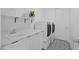 Modern laundry room featuring stainless steel machines and patterned tile flooring at 14081 Gullstrand Ave, Orlando, FL 32827