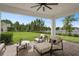 Covered outdoor patio with fan, outdoor seating, and backyard overlooking a lake at 14081 Gullstrand Ave, Orlando, FL 32827