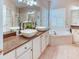 Elegant bathroom featuring double sinks, a large soaking tub, and stylish fixtures at 142 Largo Dr, Poinciana, FL 34759