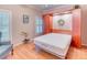 Cozy bedroom featuring hardwood floors, natural light, a Murphy bed, and a reading chair at 142 Largo Dr, Poinciana, FL 34759