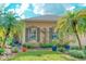 Inviting home exterior featuring lush tropical landscaping, including mature palms and vibrant plants surrounding the windows at 142 Largo Dr, Poinciana, FL 34759