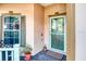 Welcoming front porch area showcasing a glass front door, stylish window trim, and decorative potted plants at 142 Largo Dr, Poinciana, FL 34759
