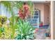 Inviting front porch, complemented by verdant tropical landscaping, creating a serene entrance at 142 Largo Dr, Poinciana, FL 34759