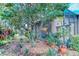Lush backyard and covered patio featuring colorful flowers and lovely landscaping at 142 Largo Dr, Poinciana, FL 34759