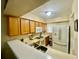 Well-lit kitchen featuring wooden cabinets, white appliances and a convenient breakfast bar at 167 Scottsdale Sq # 167, Winter Park, FL 32792