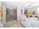 Bright bathroom featuring a glass shower, white cabinets, and a double vanity at 1959 Cricket Cradle Dr, Kissimmee, FL 34746