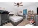Functional bedroom with a ceiling fan, bed and treadmill at 1959 Cricket Cradle Dr, Kissimmee, FL 34746