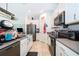 Bright kitchen with white cabinets, gray countertops and stainless steel appliances at 1959 Cricket Cradle Dr, Kissimmee, FL 34746