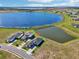 A beautiful aerial view of a home next to a large lake with a pond and manicured lawn at 224 Valencia Ridge Dr, Auburndale, FL 33823