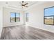 Bright bedroom with tray ceiling, ceiling fan, wood-look floors and large windows overlooking the backyard at 224 Valencia Ridge Dr, Auburndale, FL 33823