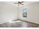 Bright bedroom featuring wood-look flooring, white walls, ceiling fan, and a window at 224 Valencia Ridge Dr, Auburndale, FL 33823