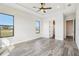 Bright bedroom with tray ceiling, ceiling fan, wood-look floors and large windows overlooking the backyard at 224 Valencia Ridge Dr, Auburndale, FL 33823