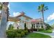 Clubhouse exterior featuring white columns, a red roof, and lush landscaping at 224 Valencia Ridge Dr, Auburndale, FL 33823