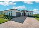 Gorgeous home exterior with stone accents, a three car garage, and brick driveway at 224 Valencia Ridge Dr, Auburndale, FL 33823