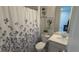 Cozy bathroom featuring a shower with floral curtain, white fixtures, and modern decor at 2508 W End Dr, St Cloud, FL 34772