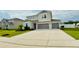 Two-story home featuring a light gray exterior, well-manicured lawn, and an attached two-car garage at 2508 W End Dr, St Cloud, FL 34772