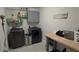 Well-organized laundry room featuring a modern washer and dryer, storage cabinets, and a folding table at 2508 W End Dr, St Cloud, FL 34772