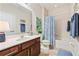 Bathroom with tile floors, single sink vanity, mirror, and shower-tub at 256 Yellow Snapdragon Dr, Davenport, FL 33837