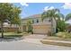 Two story home featuring a brick driveway, two car garage, well maintained lawn and manicured landscaping at 256 Yellow Snapdragon Dr, Davenport, FL 33837