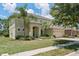 Two-story home with well-manicured lawn, colorful flowerbeds, arched entry, and attached two-car garage at 256 Yellow Snapdragon Dr, Davenport, FL 33837