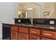 Close-up of the kitchen counter and cabinet with black granite countertop and stainless steel sink and black dishwasher at 256 Yellow Snapdragon Dr, Davenport, FL 33837