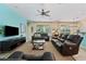 Spacious living room with leather furniture, ceiling fan, and sliding glass doors overlooking the backyard at 256 Yellow Snapdragon Dr, Davenport, FL 33837