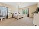 Cozy main bedroom with a four-poster bed, carpet floors, and large windows at 256 Yellow Snapdragon Dr, Davenport, FL 33837