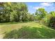 Large grassy backyard with mature trees and colorful flowers, offering plenty of outdoor space at 2571 Ames Haven Rd, Kissimmee, FL 34744