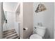 Cozy bathroom featuring a white toilet, beach decor, and wood-style flooring in a well-lit space at 2571 Ames Haven Rd, Kissimmee, FL 34744