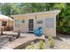 Charming cottage featuring a quaint front porch, inviting blue chair, and lush tropical landscaping at 2571 Ames Haven Rd, Kissimmee, FL 34744