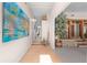 Inviting hallway with light wood floors, vibrant wall art, and an opening into a naturally lit living space at 2571 Ames Haven Rd, Kissimmee, FL 34744